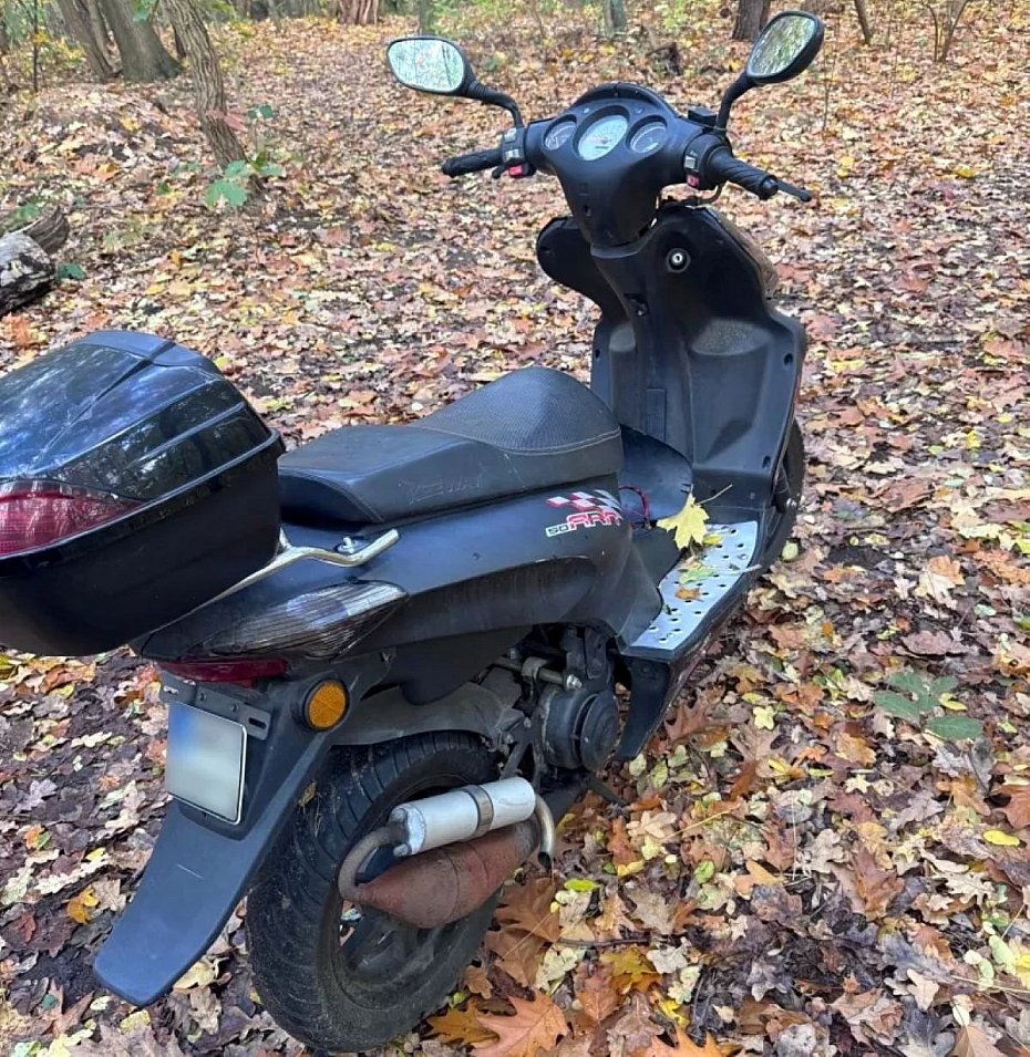 alt='Porzucony skuter w lesie. W schowku dokumenty'