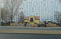 Mały, żółty domek pośrodku morza betonu